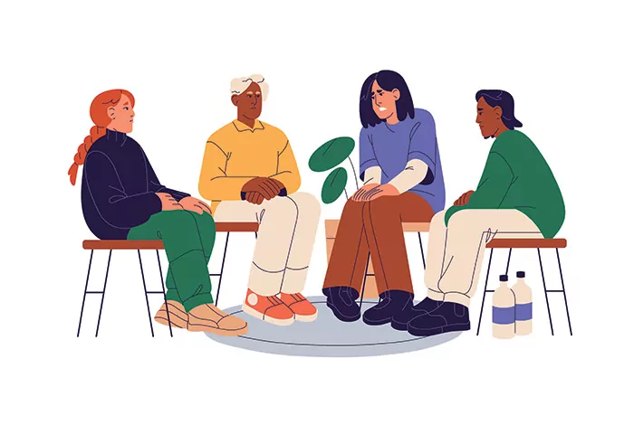 Individuals sit in a group for therapy