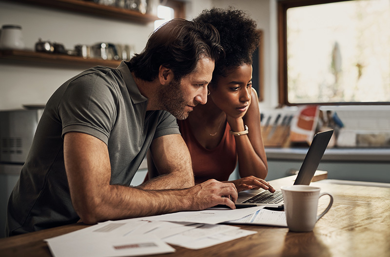 Two people look at a laptop to see if online rehab is covered by insurance